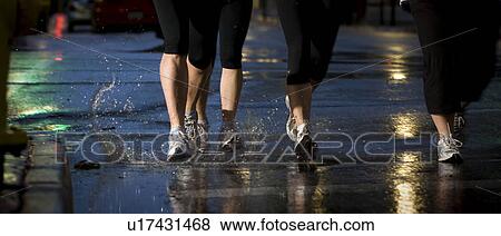Four pair of runners feet on wet pavement, Regina, Saskatchewan View Large Photo Image Stock Photo - Four pair of runners feet on wet pavement, Regina, Saskatchewan. Fotosearch