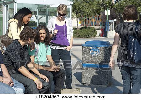 Stock Image - Group of teens talking at the transit stop, Winnipeg, Manitoba, Canada. Fotosearch