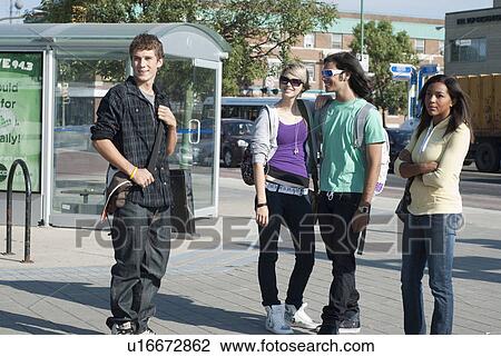 Stock Image - Group of teens waiting at the transit shelter, Winnipeg, Manitoba, Canada. Fotosearch