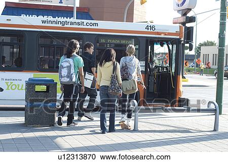Stock Image - Group of teens walking toward transit bus, Winnipeg, Manitoba, Canada. Fotosearch