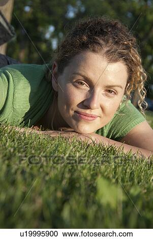 Stock Image - Headshot of woman (40's) on grass in Assinboine park, Winnipeg, Canada. Fotosearch