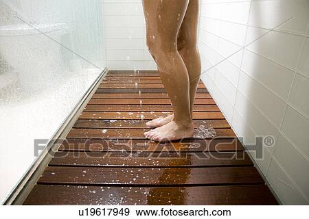 Stock Photo - Legs of woman in shower stall with low flow faucet.. Fotosearch