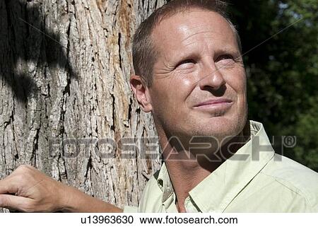 Man in 40's by tree looking upward, Winnipeg, Canada View Large Photo Image Stock Image - Man in 40's by tree looking upward, Winnipeg, Canada. Fotosearch