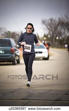 Stock Photo - Middle aged female runner in marathon, Regina, Saskatchewan. Fotosearch