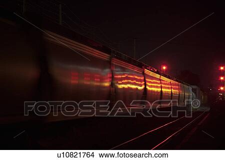 Night photo of a freight train passing red signals View Large Photo Image Picture - Night photo of a freight train passing red signals. Fotosearch