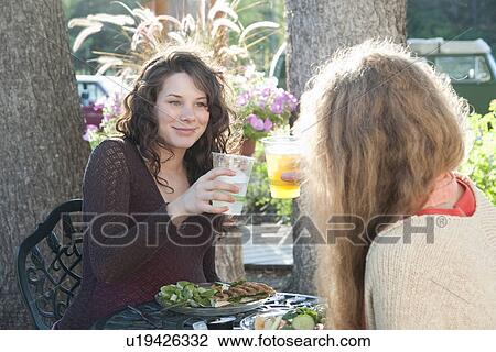 Stock Image - Pregnant woman and friend eating at outdoor restaurant, Manitoba, Canada. Fotosearch