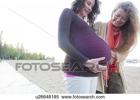 Stock Photography - Pregnant woman and friend on beach boardwalk, Clear Lake, Manitoba, Canada. Fotosearch