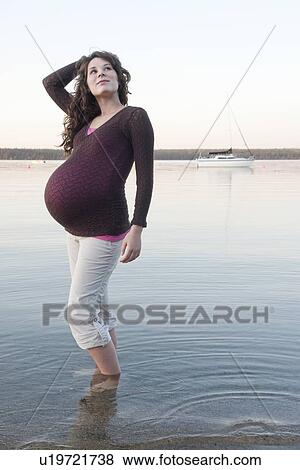 Pregnant woman standing in shallow water, Clear Lake, Manitoba, Canada View Large Photo Image Stock Photo - Pregnant woman standing in shallow water, Clear Lake, Manitoba, Canada. Fotosearch