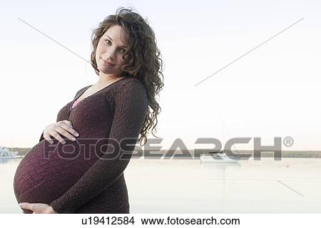 Pregnant woman with hands on abdomen, Clear Lake, Manitoba, Canada View Large Photo Image Picture - Pregnant woman with hands on abdomen, Clear Lake, Manitoba, Canada. Fotosearch