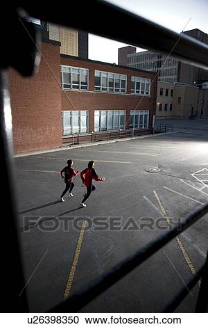 Rear view of two runners and dog very early morning in urban parking lot, Regina Saskatchewan View Large Photo Image Stock Image - Rear view of two runners and dog very early morning in urban parking lot, Regina Saskatchewan. Fotosearch