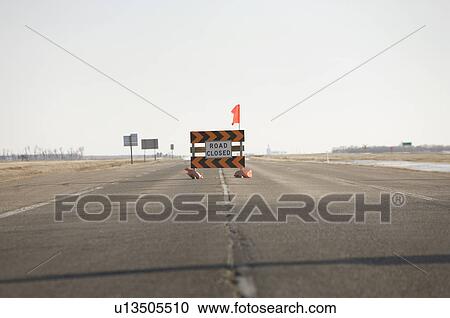 Stock Image - Road Closed sign in middle of highway, due to Red River flooding highway, rural Manitoba. Fotosearch