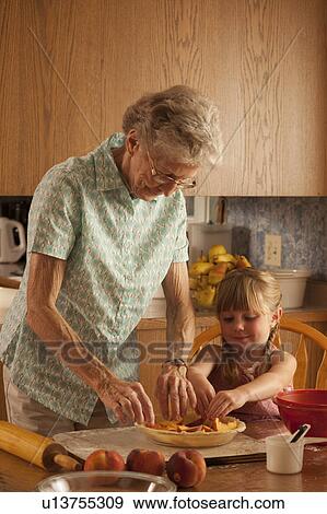 Senior woman and five year old girl placing peaches in pie plate; Redvers, Saskatchewan, Canada View Large Photo Image Stock Photo - Senior woman and five year old girl placing peaches in pie plate; Redvers, Saskatchewan, Canada. Fotosearch