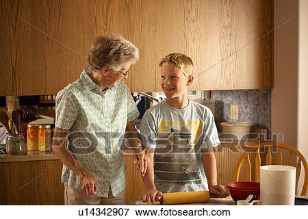 Stock Photo - Senior woman and her 12 year old great grandson rolling out pastry, Redvers, Saskatchewan, Canada. Fotosearch