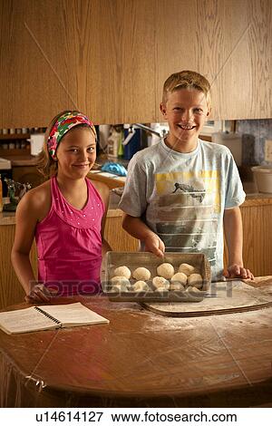 Sister (10) and brother (12) show off pan of unbaked buns; Redvers, Saskatchewan, Canada View Large Photo Image Stock Photo - Sister (10) and brother (12) show off pan of unbaked buns; Redvers, Saskatchewan, Canada. Fotosearch