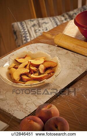 Stock Image - Sliced peaches in pie shell, Redvers, Saskatchewan, Canada. Fotosearch