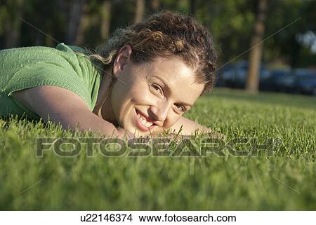Picture - Smiling woman on the grass, Assiniboine park, Winnipeg, Canada. Fotosearch