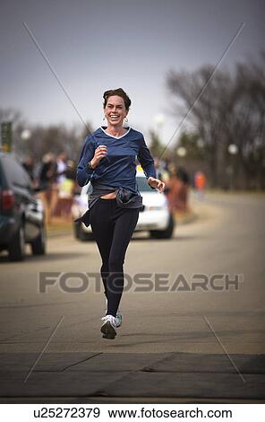 Stock Photo - Smiling woman running in marathon, Regina, Saskatchewan. Fotosearch