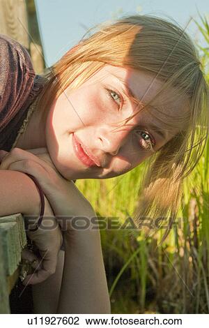 Stock Image - Teen hanging over edge of boardwalk in marsh, Riding Mountain National Park, Manitoba, Canada. Fotosearch