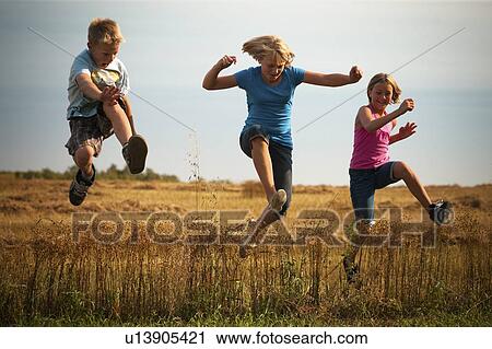 Three tween kids jumping the swath in flax field; Redvers, Saskatchewan, Canada View Large Photo Image Stock Image - Three tween kids jumping the swath in flax field; Redvers, Saskatchewan, Canada. Fotosearch