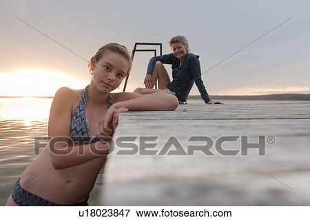 Tween girl leans on dock, Mom seated on dock, Riding Mountain National Park, Manitoba, Canada View Large Photo Image Stock Photo - Tween girl leans on dock, Mom seated on dock, Riding Mountain National Park, Manitoba, Canada. Fotosearch