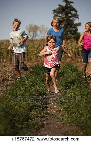 Twelve, ten, and five year old girls and twelve year old boy run in the garden; Redvers, Saskatchewan, Canada View Large Photo Image Stock Image - Twelve, ten, and five year old girls and twelve year old boy run in the garden; Redvers, Saskatchewan, Canada. Fotosearch