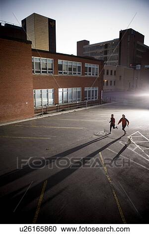 Stock Image - Two runners very early morning in urban parking lot, Regina Saskatchewan. Fotosearch
