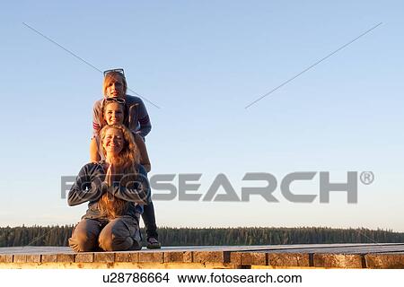Two teen girls and woman in 50's posing on dock by lake, Riding Mountain National Park, Manitoba, Canada View Large Photo Image Picture - Two teen girls and woman in 50's posing on dock by lake, Riding Mountain National Park, Manitoba, Canada. Fotosearch