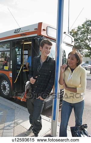 Stock Photography - Two teens at bus stop, Winnipe, Manitoba, Canada. Fotosearch