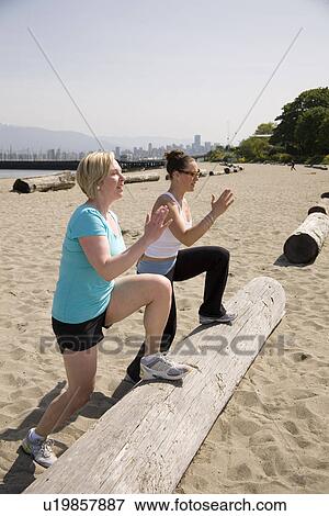 Two women doing step ups on log at beach, Vancouver, BC View Large Photo Image Stock Photo - Two women doing step ups on log at beach, Vancouver, BC. Fotosearch