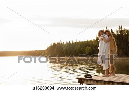 Two women embrace on dock, Clear Lake, Manitoba, Canada View Large Photo Image Picture - Two women embrace on dock, Clear Lake, Manitoba, Canada. Fotosearch