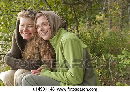 Two women huddled outdoors, Clear Lake, Manitoba, Canada View Large Photo Image Stock Photo - Two women huddled outdoors, Clear Lake, Manitoba, Canada. Fotosearch