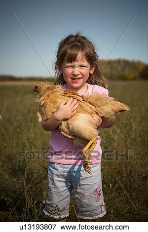 Two year old girl hold heritage breed, free-range chicken; Redvers, Saskatchewan, Canada View Large Photo Image Stock Photo - Two year old girl hold heritage breed, free-range chicken; Redvers, Saskatchewan, Canada. Fotosearch