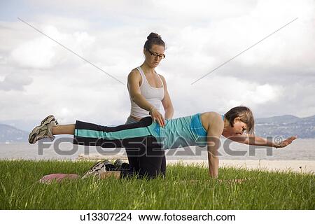 Woman and instructor doing yoga in park, Vancouver, BC View Large Photo Image Picture - Woman and instructor doing yoga in park, Vancouver, BC. Fotosearch