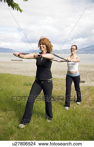 Woman and instructor using yoga bands on beach, Vancouver, BC View Large Photo Image Picture - Woman and instructor using yoga bands on beach, Vancouver, BC. Fotosearch