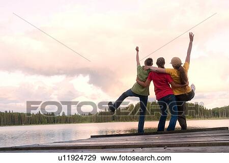 Woman and two girls celebrating at end of dock, Lake Katherine, Manitoba, Canada View Large Photo Image Stock Photo - Woman and two girls celebrating at end of dock, Lake Katherine, Manitoba, Canada . Fotosearch