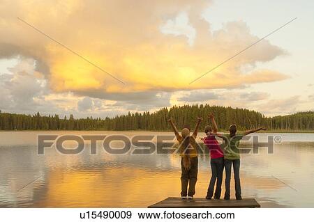 Woman and two girls with arms upward, majestic clouds and lake, Lake Katherine, Manitoba, Canada View Large Photo Image Stock Photo - Woman and two girls with arms upward, majestic clouds and lake, Lake Katherine, Manitoba, Canada. Fotosearch