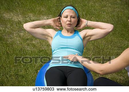 Woman doing abdominal exercises on ball in park, Vancouver, BC View Large Photo Image Stock Image - Woman doing abdominal exercises on ball in park, Vancouver, BC. Fotosearch