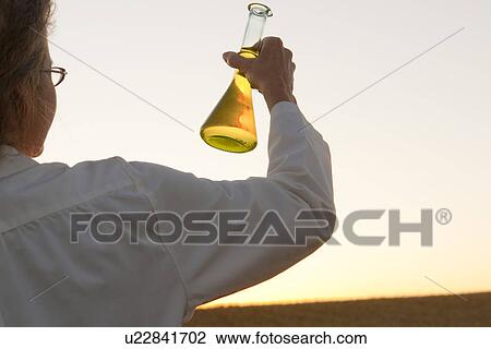 Woman holding flask up at sunset, Manitoba, Canada View Large Photo Image Stock Image - Woman holding flask up at sunset, Manitoba, Canada. Fotosearch