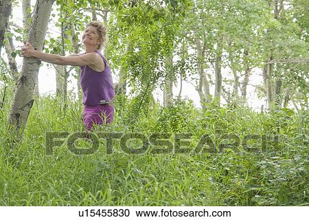 Woman holds poplar tree in grove of trees, Manitoba, Canada View Large Photo Image Stock Image - Woman holds poplar tree in grove of trees, Manitoba, Canada. Fotosearch