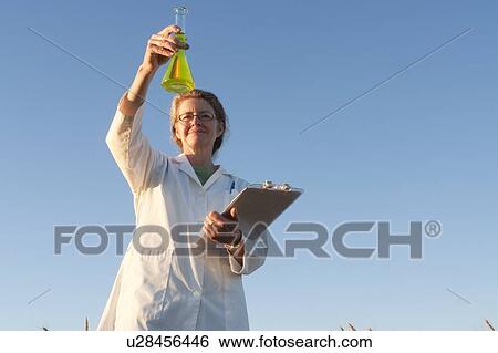 Woman in field of wheat holds clipboard and flask, Manitoba, Canada View Large Photo Image Stock Photograph - Woman in field of wheat holds clipboard and flask, Manitoba, Canada. Fotosearch