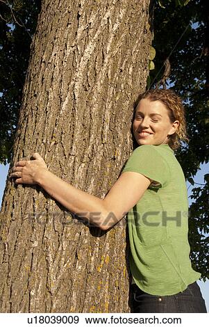 Woman in her 40's hugs tree in park, Winnipeg, Canada View Large Photo Image Stock Photo - Woman in her 40's hugs tree in park, Winnipeg, Canada. Fotosearch