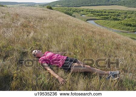 Woman laying on hillside, rural Manitoba, Canada View Large Photo Image Stock Photograph - Woman laying on hillside, rural Manitoba, Canada. Fotosearch