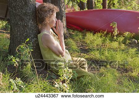 Woman leans against tree with hands together, Clear Lake, Manitoba View Large Photo Image Stock Photo - Woman leans against tree with hands together, Clear Lake, Manitoba. Fotosearch
