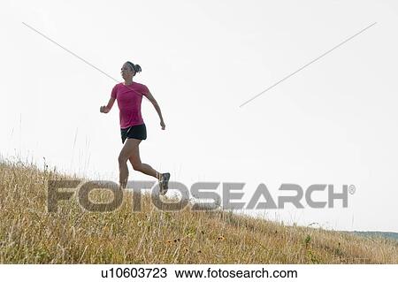 Woman running up hill, rural Manitoba, Canada View Large Photo Image Stock Image - Woman running up hill, rural Manitoba, Canada. Fotosearch