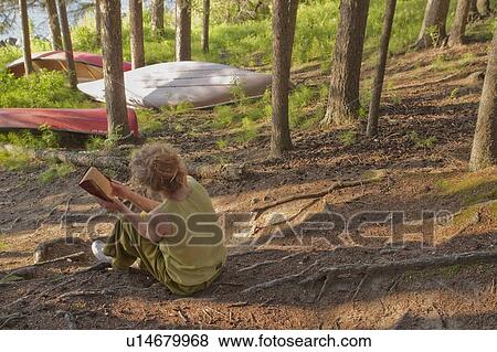 Woman seated in grove of trees beside lake reading a book, Clear Lake, Riding Mountain National Park, Manitoba, Canada View Large Photo Image Stock Photo - Woman seated in grove of trees beside lake reading a book, Clear Lake, Riding Mountain National Park, Manitoba, Canada. Fotosearch