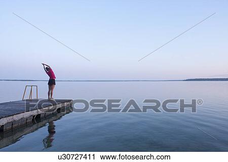 Woman stretching on dock by lake, Clear Lake, Riding Mountain National Park, Manitoba, Canada View Large Photo Image Stock Image - Woman stretching on dock by lake, Clear Lake, Riding Mountain National Park, Manitoba, Canada. Fotosearch