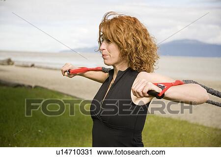 Stock Image - Woman using yoga bands, Vancouver, BC. Fotosearch