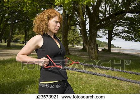 Stock Image - Woman using yoga bands, Vancouver, BC. Fotosearch