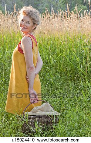 Woman with basket beside tall grass, Manitoba, Canada View Large Photo Image Stock Image - Woman with basket beside tall grass, Manitoba, Canada. Fotosearch