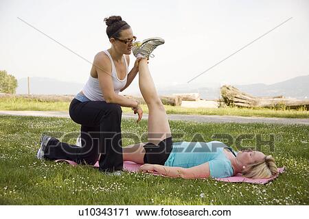 Stock Image - Yoga Instructor and woman in park, Vancouver. BC. Fotosearch
